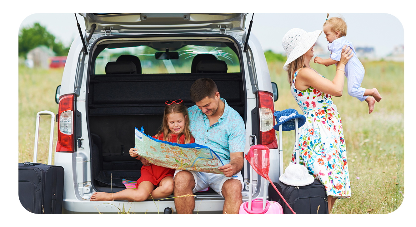 foto de uma familia com seus dois filhos em um carro com o porta malas aberto