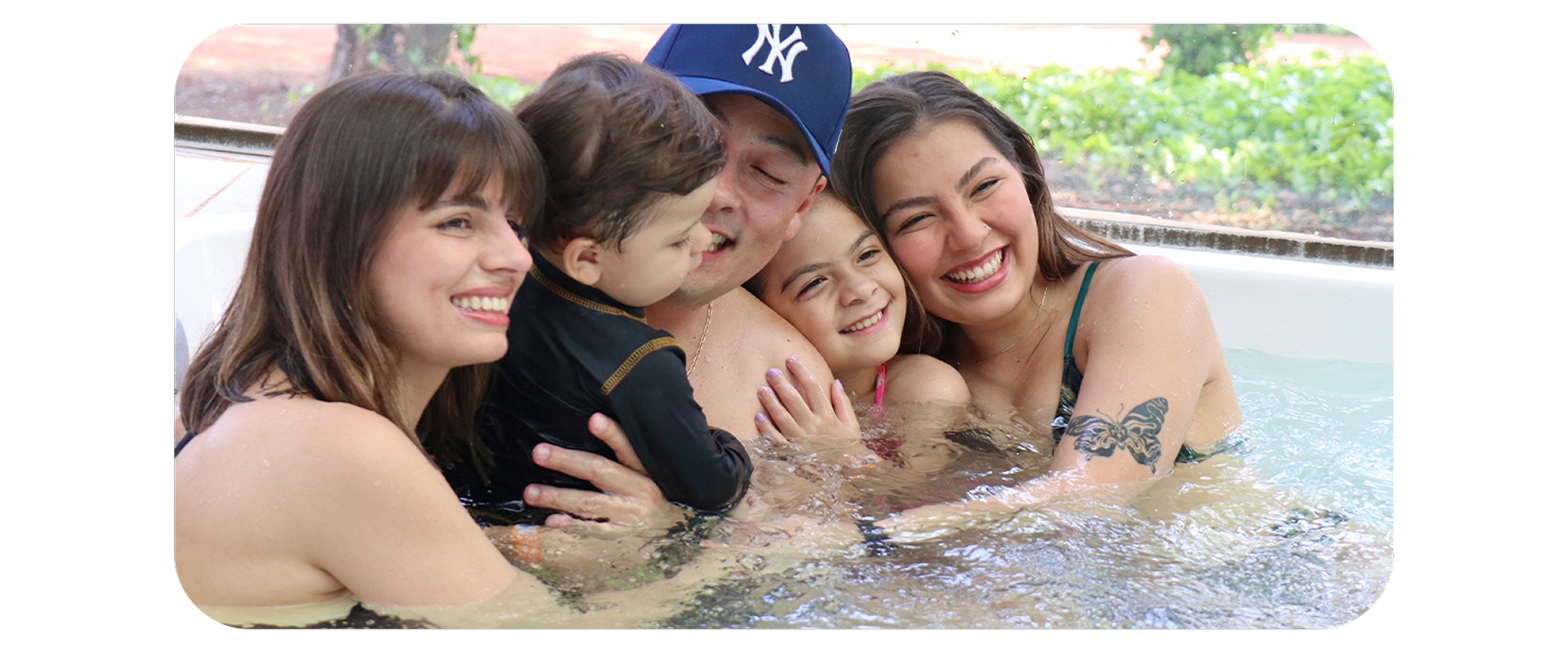 Família sorridente se diverte em hidromassagem no Aguativa Golf Resort, curtindo momento juntos.