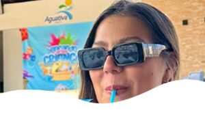 Família tomando drinks ao ar livre em resort com banner e logo do Aguativa ao fundo.