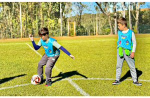 Dois garotos jogam futebol no campo do Aguativa.