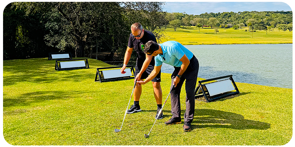 Instrutor de golfe orienta um hóspede do Aguativa em uma aula particular do esporte.