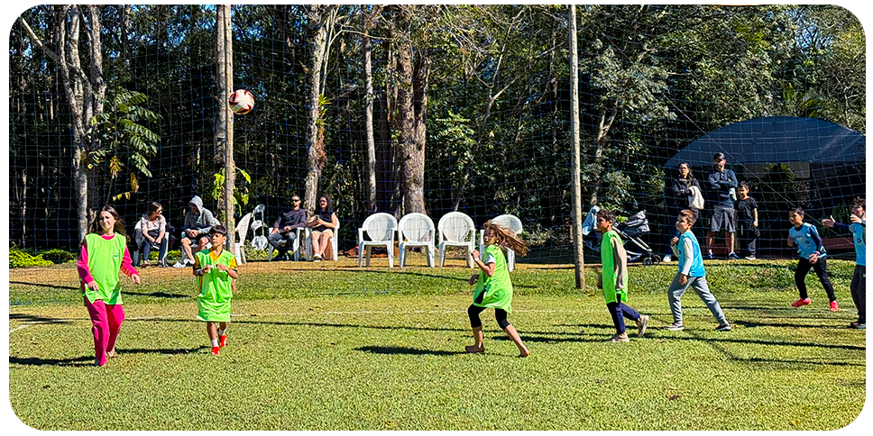 Crianças correm no campo de futebol do Aguativa durante uma partida.