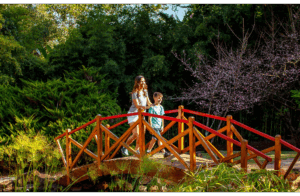 Dois hóspedes atravessam a ponte do Jardim Japonês do Aguativa.