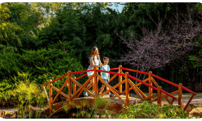Dois hóspedes atravessam a ponte do Jardim Japonês do Aguativa.