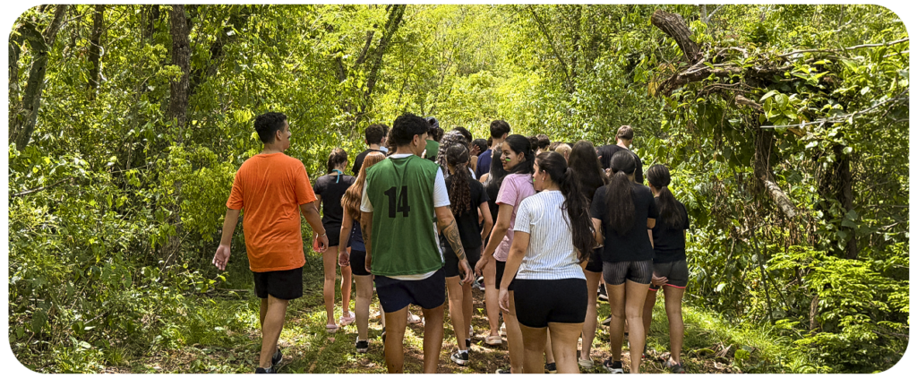 Hóspedes caminhando por uma trilha em meio às árvores.