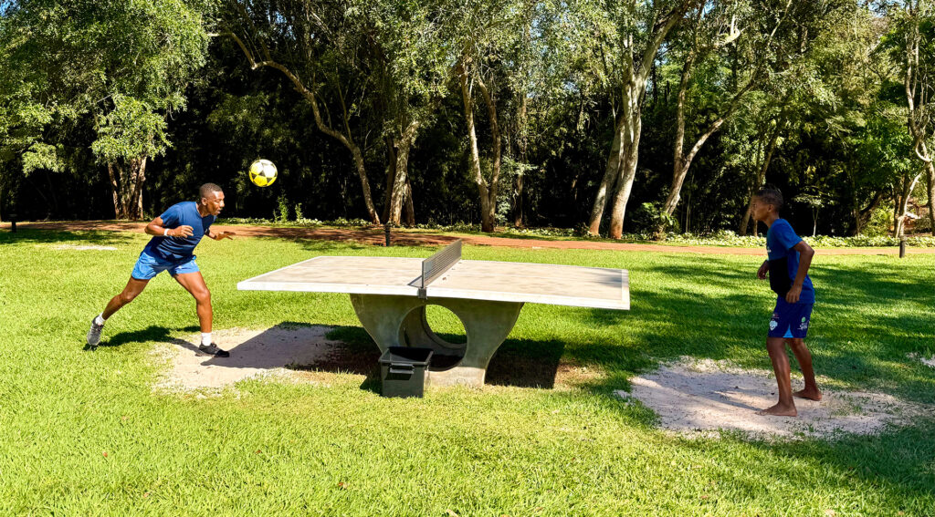 Hóspedes do Aguativa praticando futmesa ao ar livre.