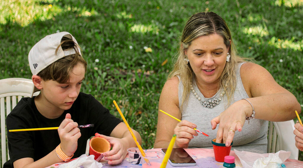Dois hóspedes de diferentes idades participando de uma oficina de pintura no Aguativa.